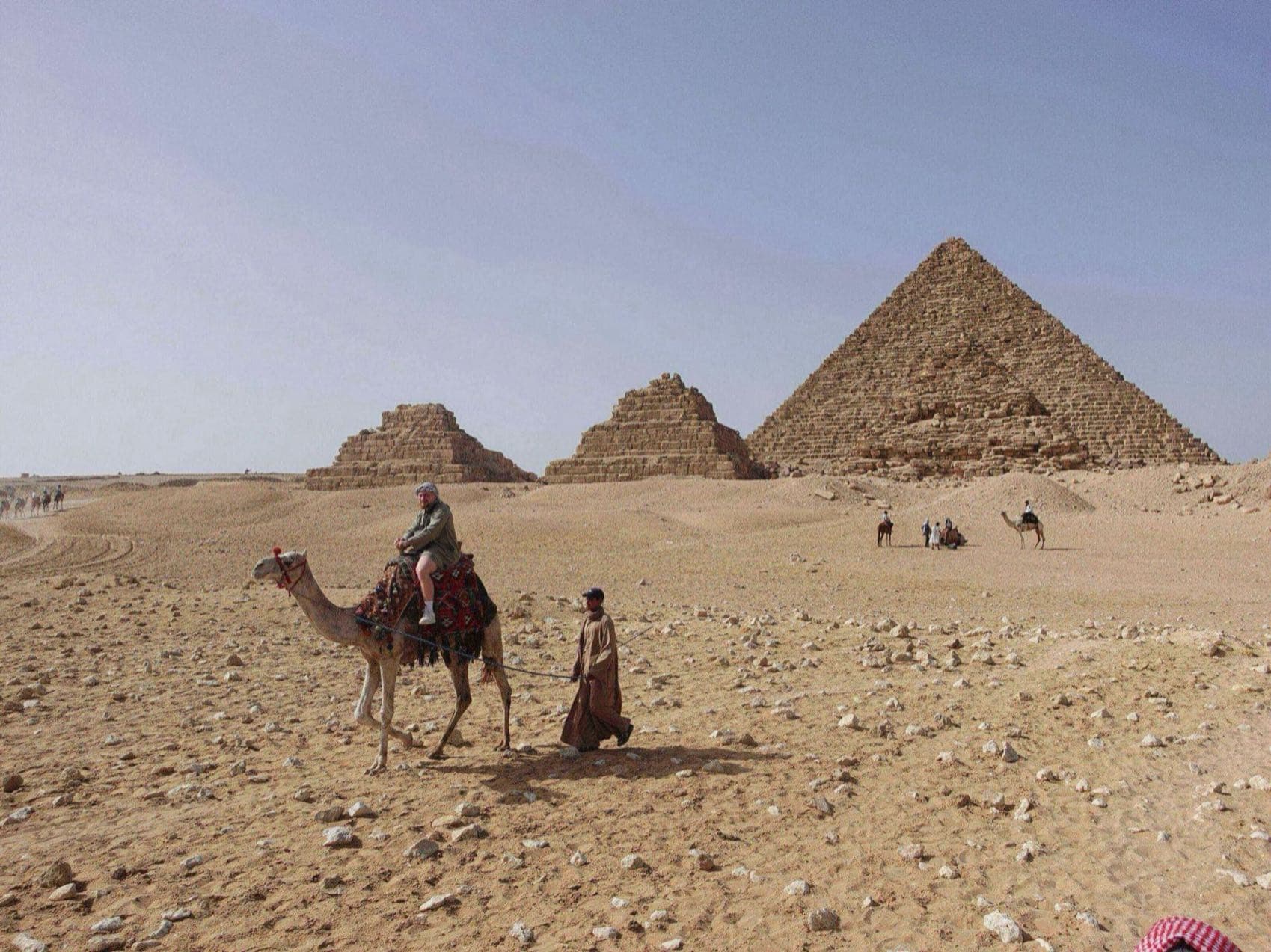 Person riding a camel near the pyramids in Egypt